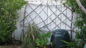garden trellis made from locally gathered sticks and cut up pieces of old t-shirts
